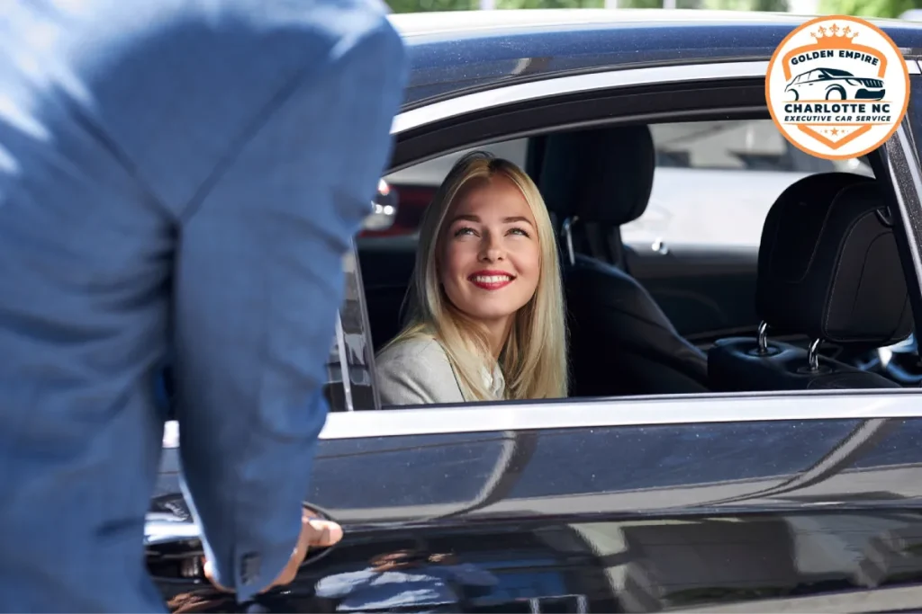A woman smiles as a chauffeur opens the door of a black executive car